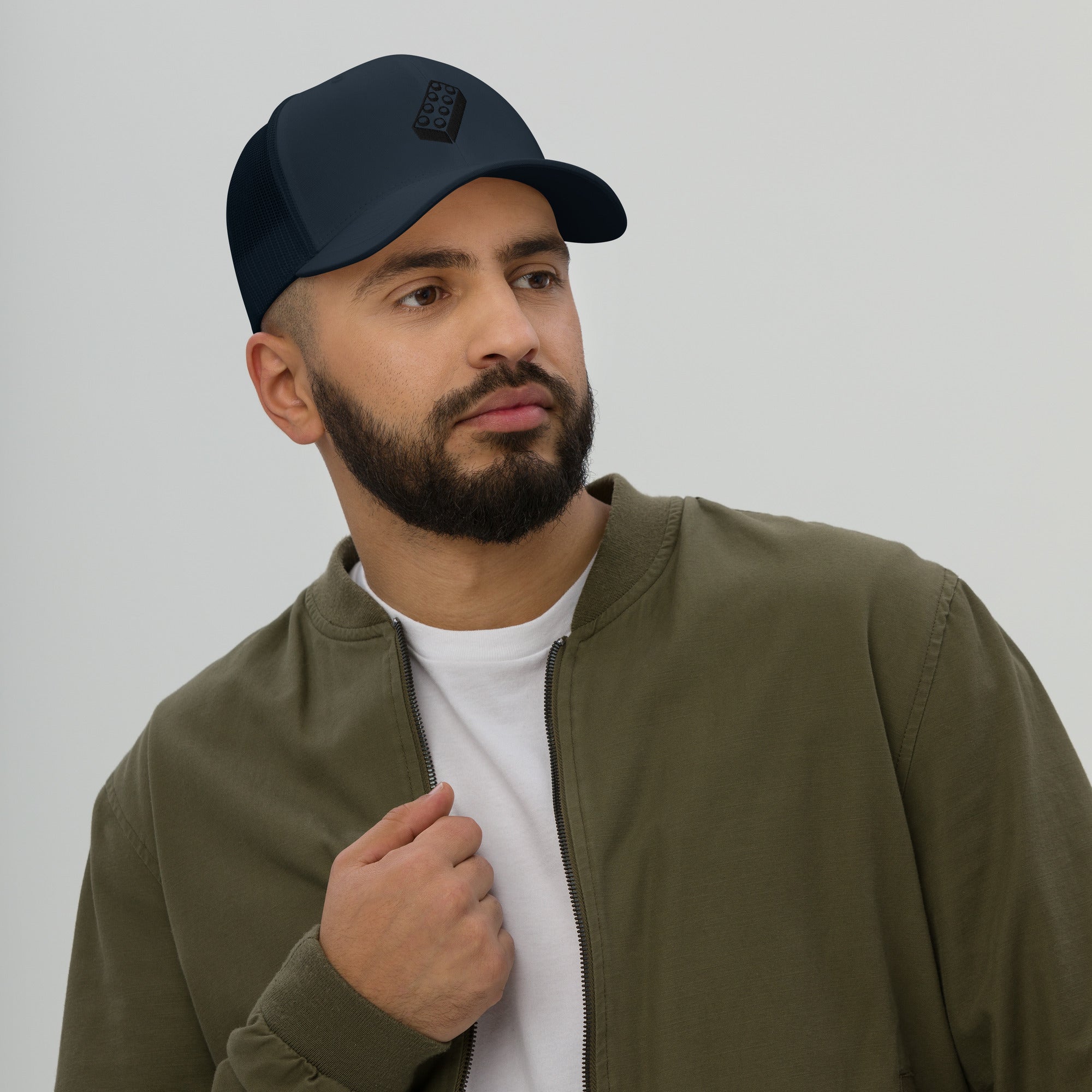 male model wearing an navy blue lego brick trucker hat